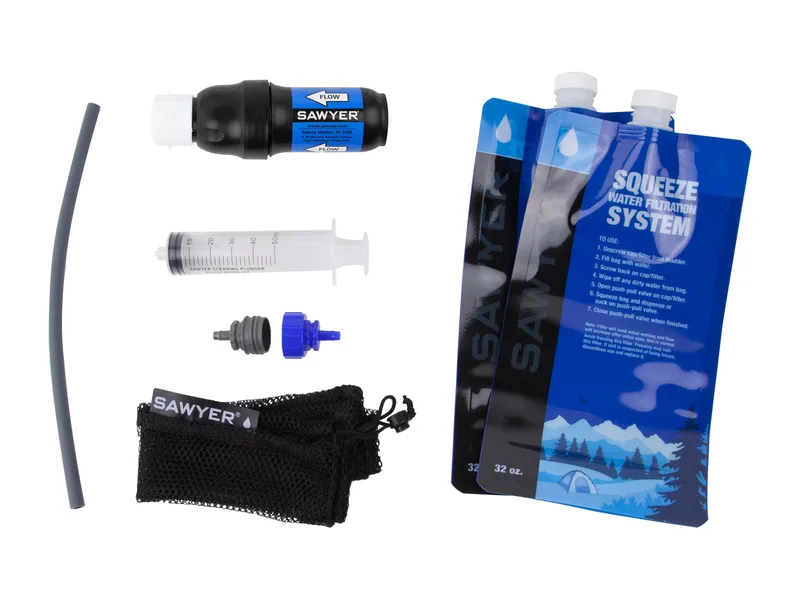 Sawyer Squeeze filter kit laid out: filter, two 32-oz pouches, cleaning syringe, straw, adapters and mesh bag